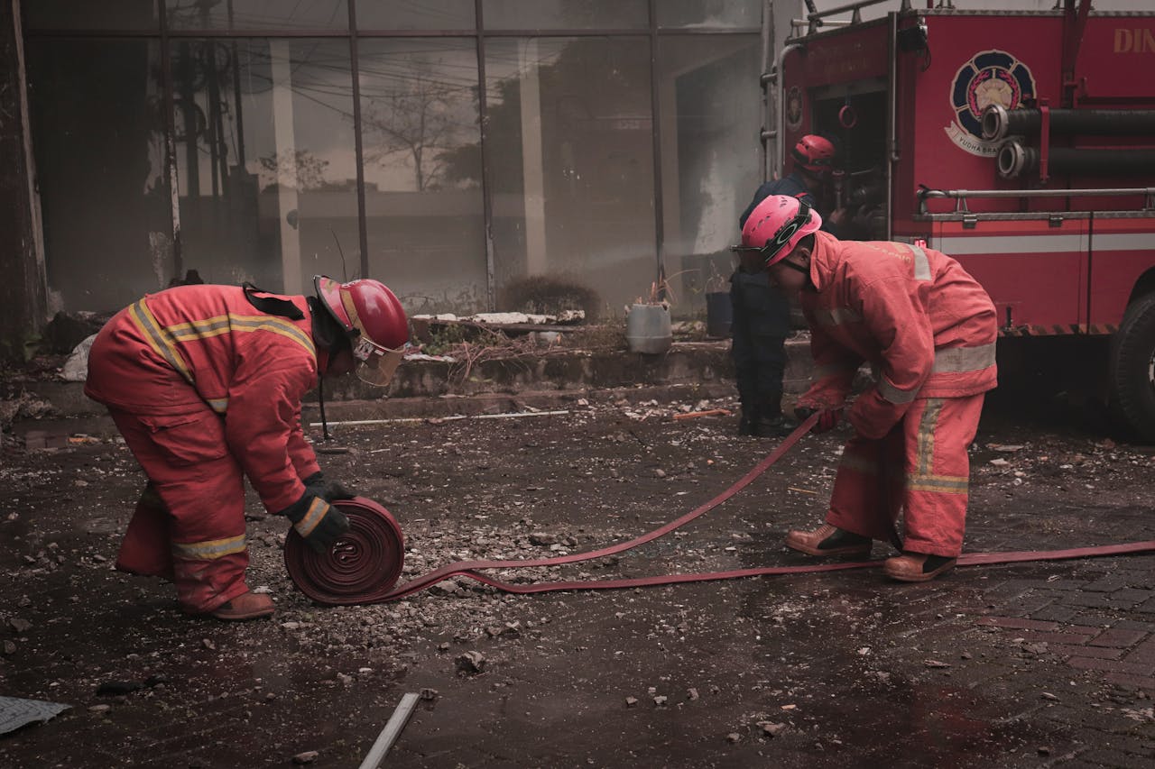 Firefighters manage hoses during a city street operation in Makassar, Indonesia.